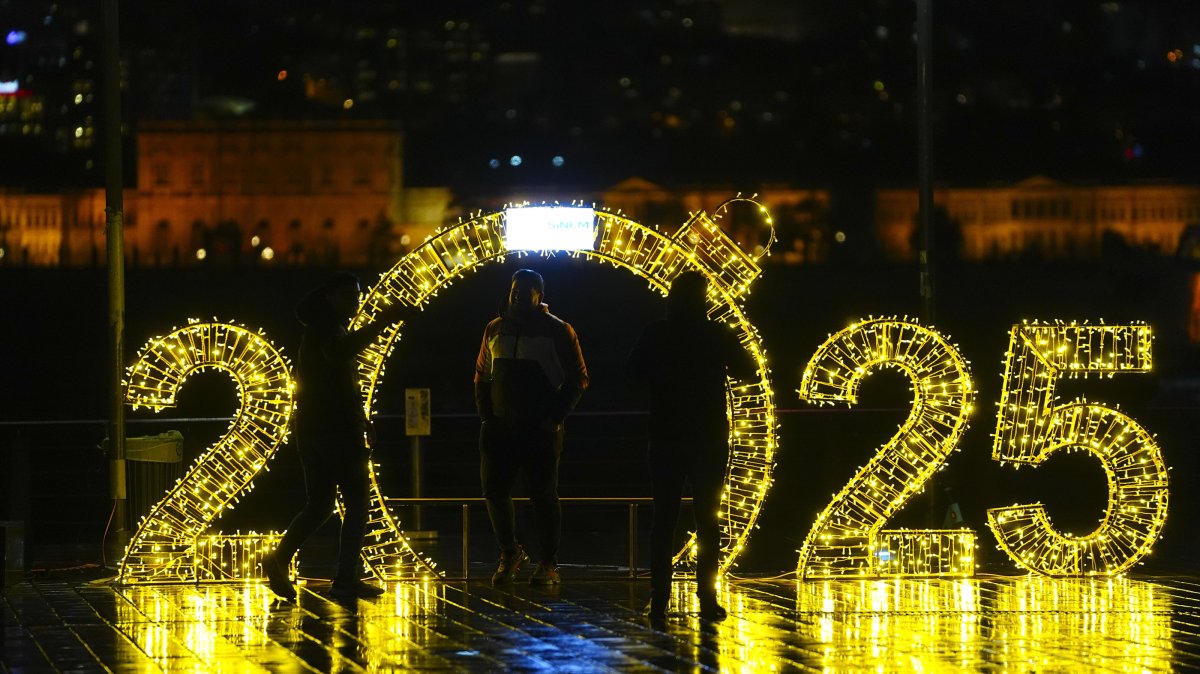 A group of friends take pictures at the 2025 New Year's decorations by the Bosporus, Istanbul, Türkiye, Dec. 29, 2024. (AA Photo)