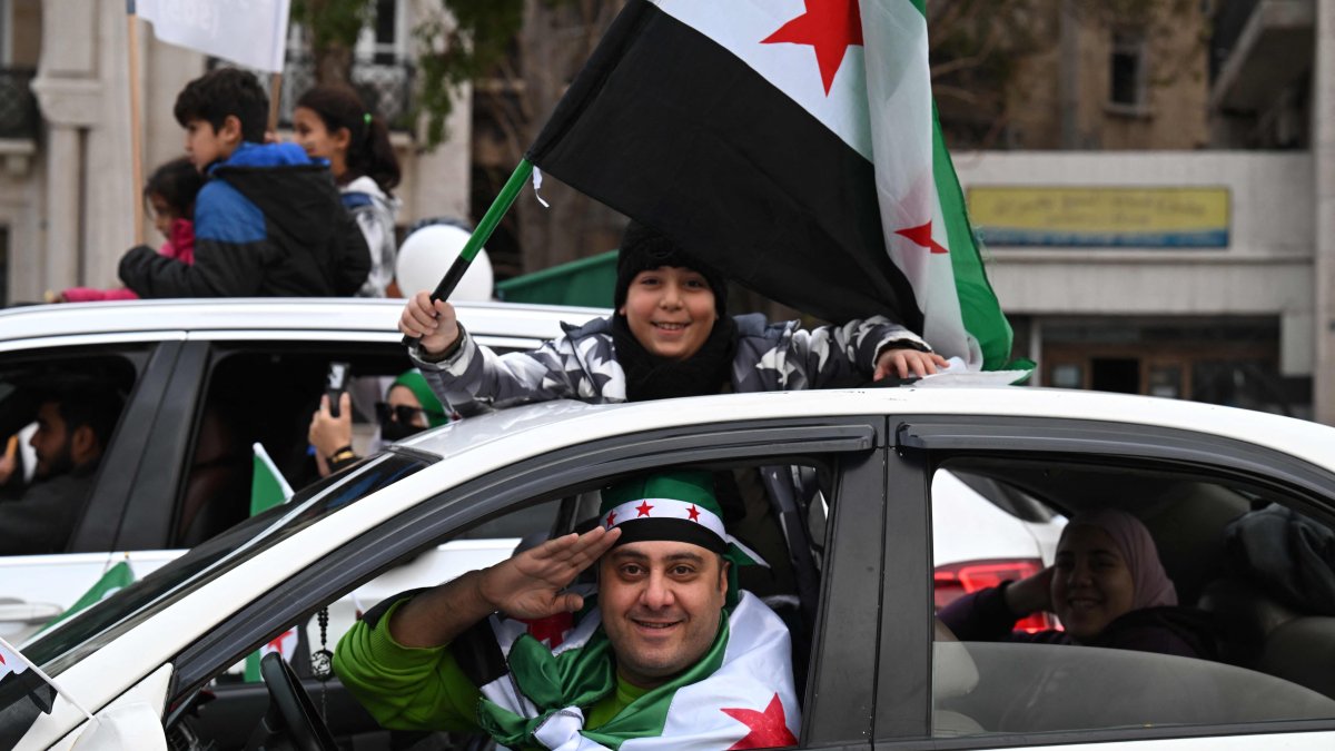 A boy waves a Syrian flag as they celebrate a year since the ousting of longtime ruler Bashar Assad in the capital Damascus, Syria, Dec. 8, 2025. (AFP Photo)