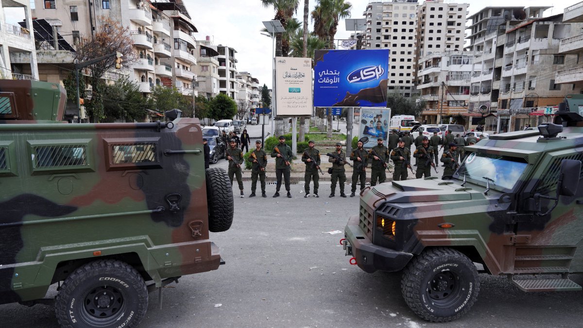 Members of the Syrian Security forces stand guard near military vehicles in Latakia, Syria, Dec. 28, 2025. (Reuters File Photo)