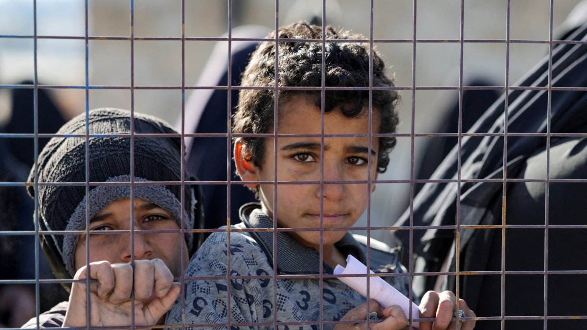 Children, part of a group of detainees, look through a fence at al-Hol camp after the Syrian government took control of it following the withdrawal of Syrian Democratic Forces (SDF), in Hassakeh, Syria, Jan. 21, 2026. (Reuters File Photo)