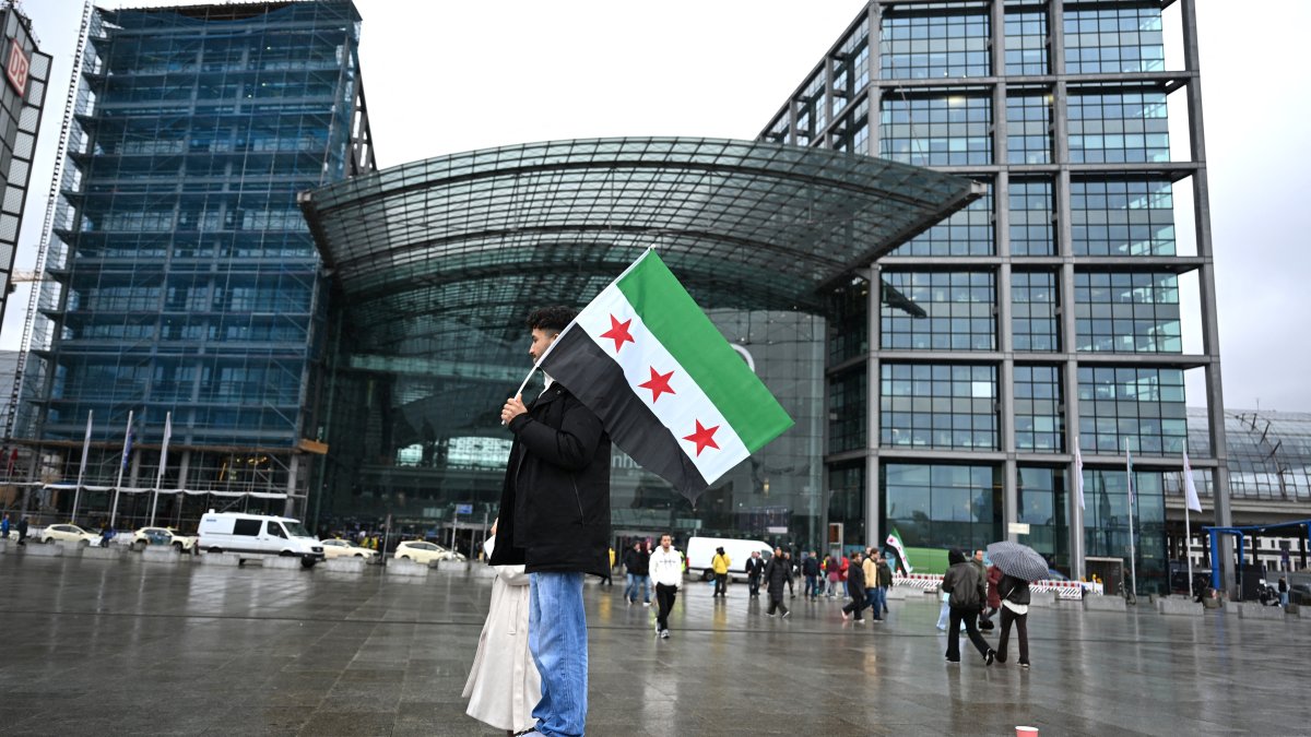 A participant holds up a Syrian flag at a pro-Syrian rally on Washingtonplatz, Berlin, March 30, 2026. (AFP Photo)