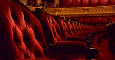 Rows of plush red velvet opera chairs with ornate gold trim. (Getty Images Photo)