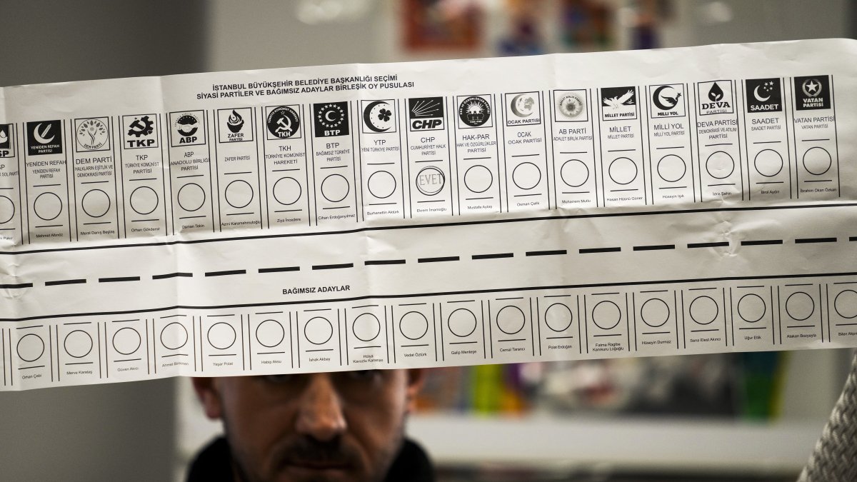 An election representative holds a ballot with the names of parties at a polling station, Istanbul, Türkiye, March 31, 2024. (AP Photo)