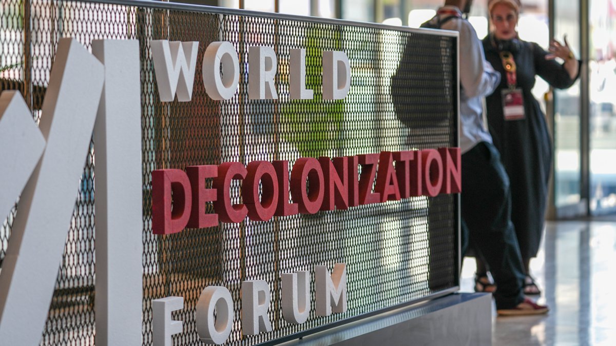 People stand near the entrance logo of the World Decolonization Forum at the Atatürk Cultural Center (AKM), Istanbul, Türkiye, May 11, 2026. (AA Photo)