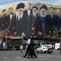 Iranians walk in front of a large billboard displaying pictures of late Iranian supreme leader Ayatollah Ali Khamenei and late Iranian president Ebrahim Raisi at the Enghelab Square in Tehran, Iran, May 21, 2026. (EPA Photo)