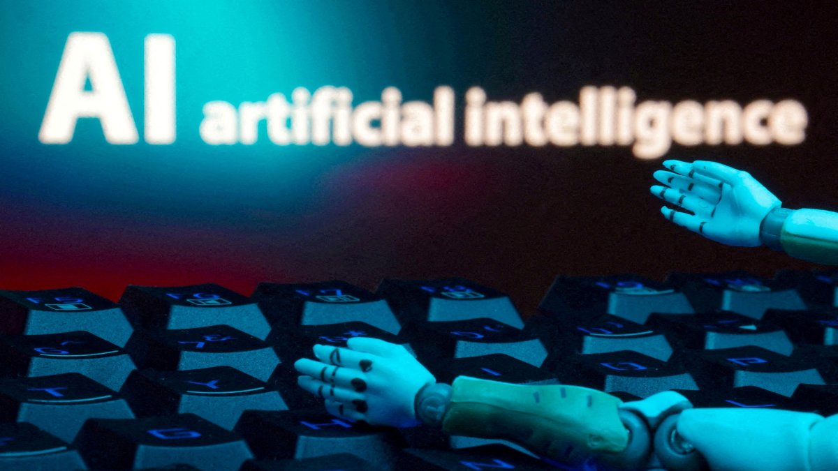 A message reading "AI artificial intelligence," a keyboard and robot hands are seen in this illustration created on Jan. 27, 2025. (Reuters File Photo)