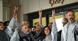 Members of the Global Sumud Flotilla, headed for Gaza and arrested and deported by Israel, pose outside a terminal following their arrival at Istanbul Airport on May 21, 2026. (AFP Photo)